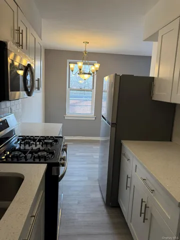 a kitchen with granite countertop a refrigerator and a stove