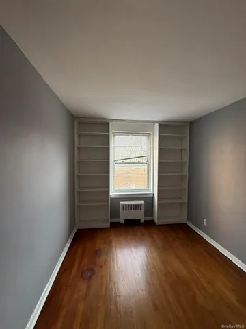 an empty room with a hardwood and a window