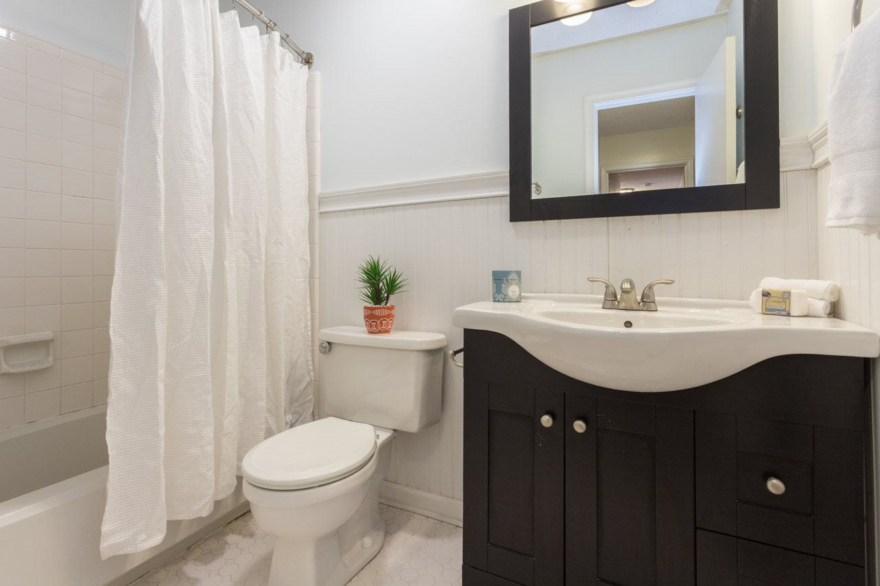 7704 Nugget Lane Raleigh, NC 27615 - Photo 17 of 18 The updated hall bath has classic stylings, and also features tile floors, tile tub-surround, wainscoting, and updated vanity and sink.
