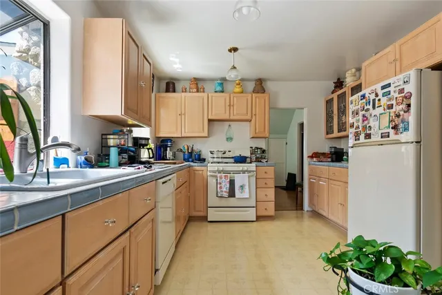 a kitchen with white cabinets and white appliances