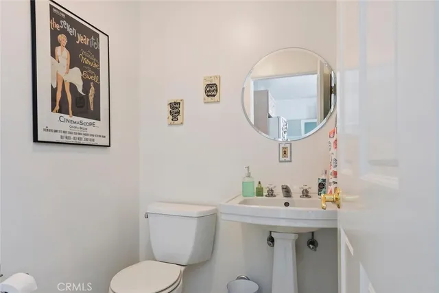 a bathroom with a toilet a sink and mirror
