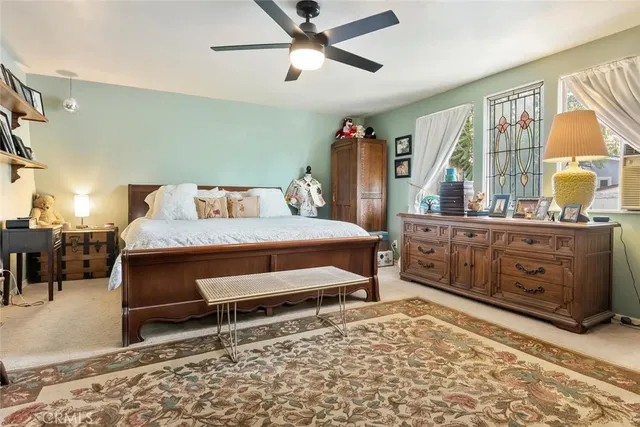 a bedroom with a bed and a flat tv screen on the dresser