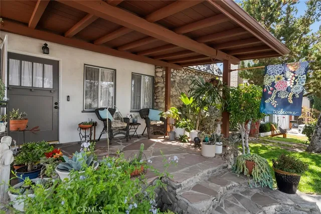 a view of a patio with table and chairs potted plants