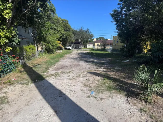 a view of a yard with plants and trees
