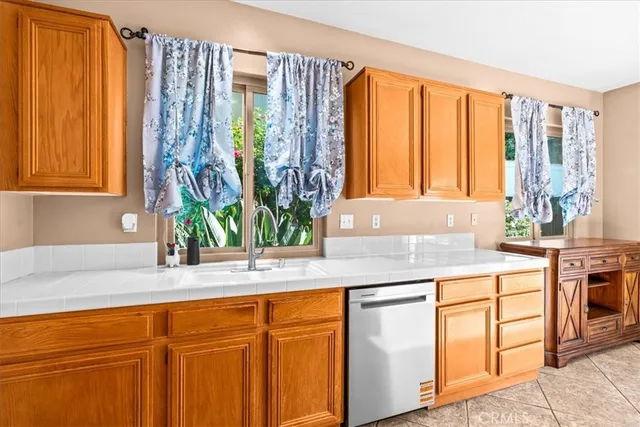 a kitchen with stainless steel appliances granite countertop a sink a counter space and a wooden floor
