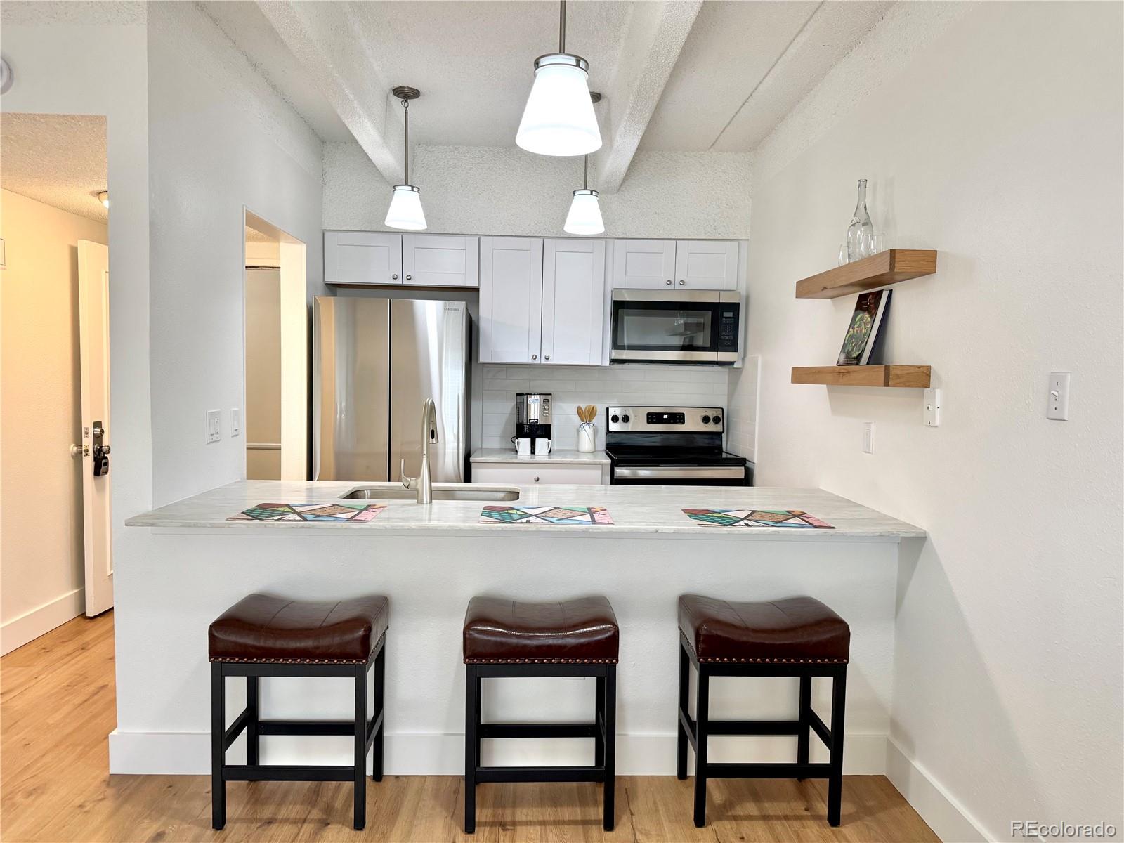 a kitchen with stainless steel appliances a stove a sink island and a refrigerator