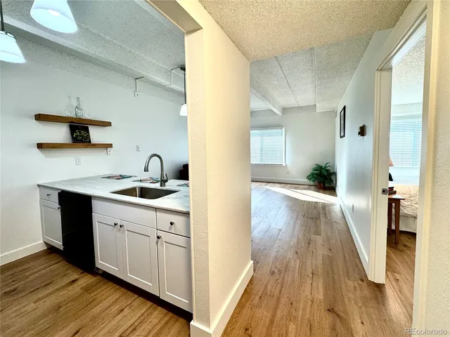 a kitchen with wooden floors and white cabinets