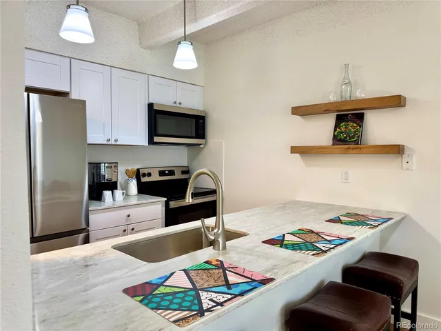 a kitchen with a stove a refrigerator and a sink