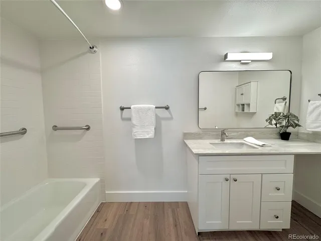 a bathroom with a sink a tub and a mirror