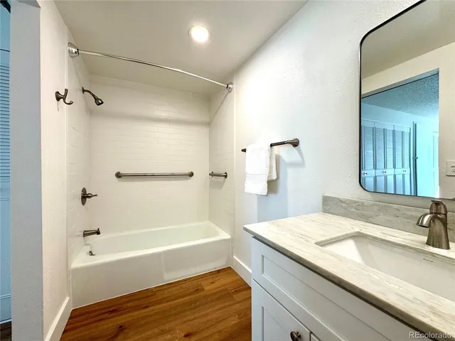 a bathroom with a granite countertop sink and a bathtub