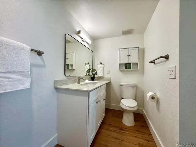 a bathroom with a sink a toilet a mirror and shower