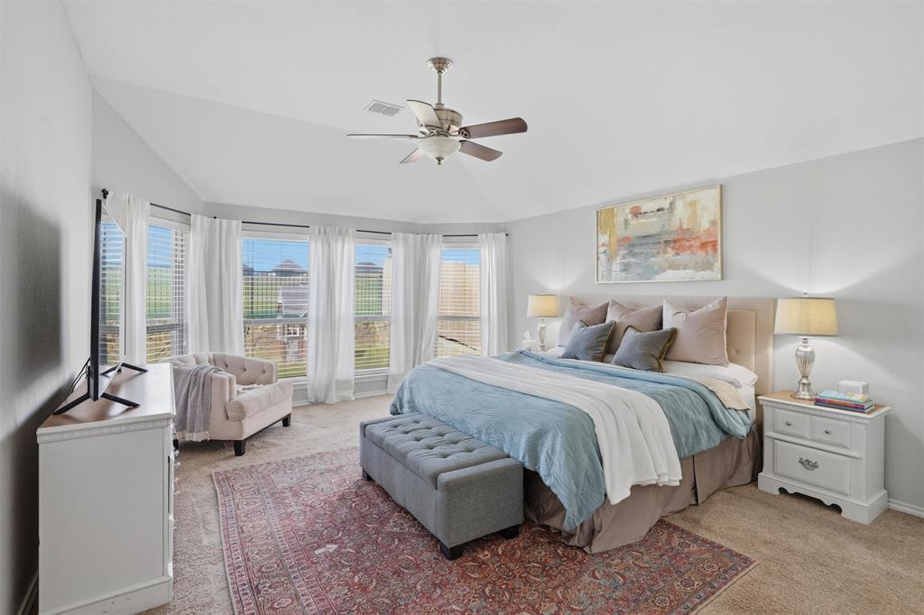 7224 Prestwick Terrace Benbrook, TX 76126 - Photo 11 of 26 This primary suite offers a stunning window bank with sitting area, elegant tray-style vaulted ceiling providing a private, tranquil feel. A true primary retreat designed for comfort.