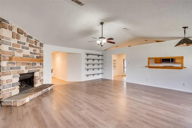 an empty room with windows and fireplace