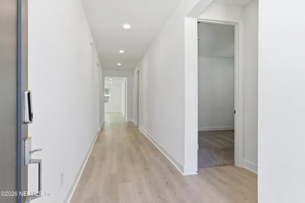 a view of a hallway with wooden floor