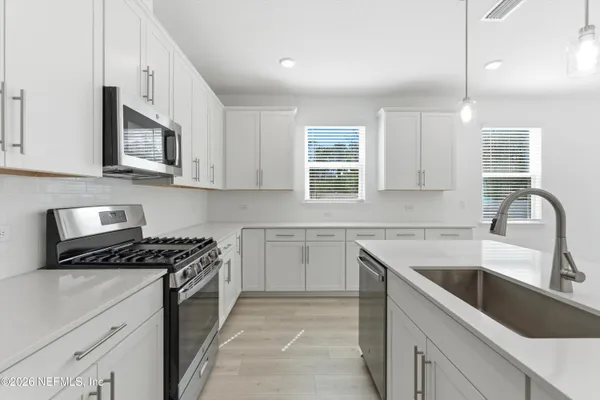 a kitchen with stainless steel appliances granite countertop a sink stove microwave and cabinets