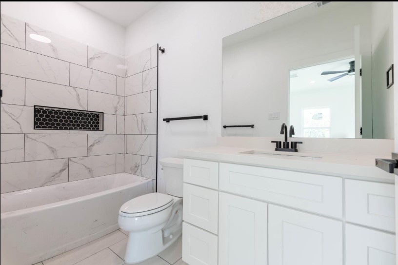 408 Armstrong Street, Unit B Houston, TX 77029 - Photo 12 of 14 a bathroom with a bathtub a sink a toilet and a mirror
