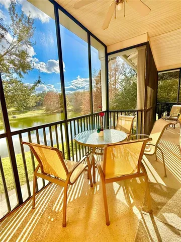 a view of a dining room and livingroom with furniture wooden floor a rug a flat screen tv and a chandelier