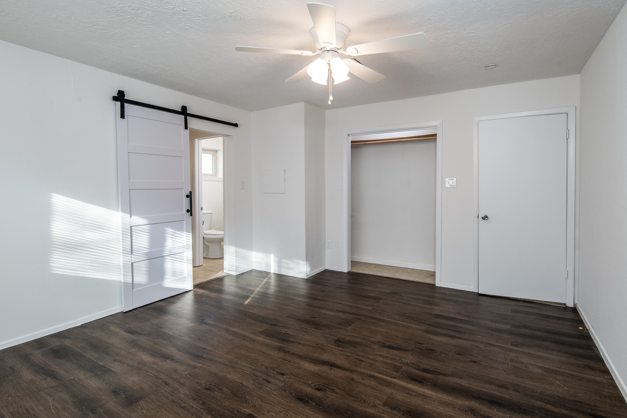 9707 Whitepost Lane Houston, TX 77086 - Photo 13 of 30 a view of an empty room with wooden floor and a window