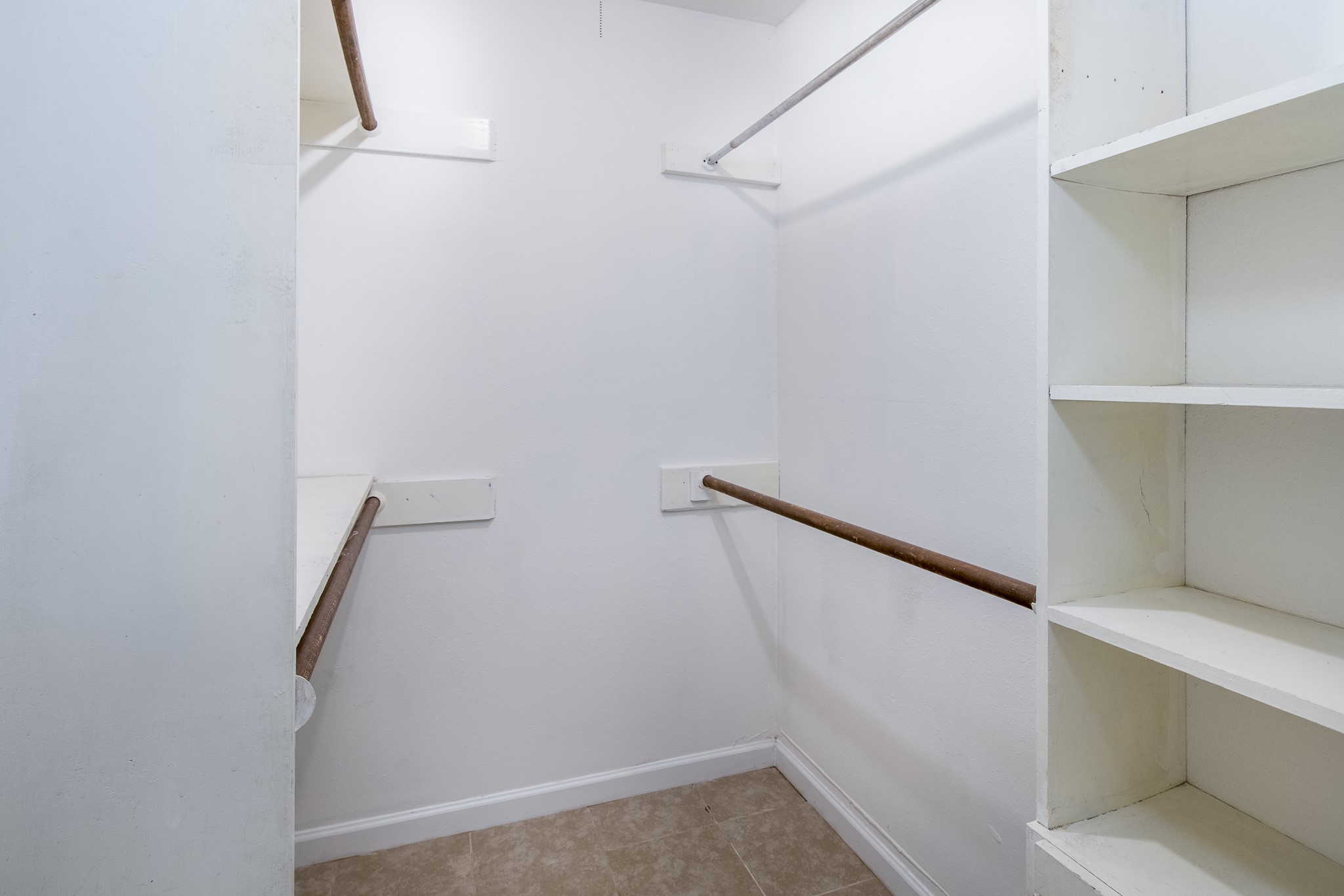 9707 Whitepost Lane Houston, TX 77086 - Photo 16 of 30 a view of walk in closet with empty racks