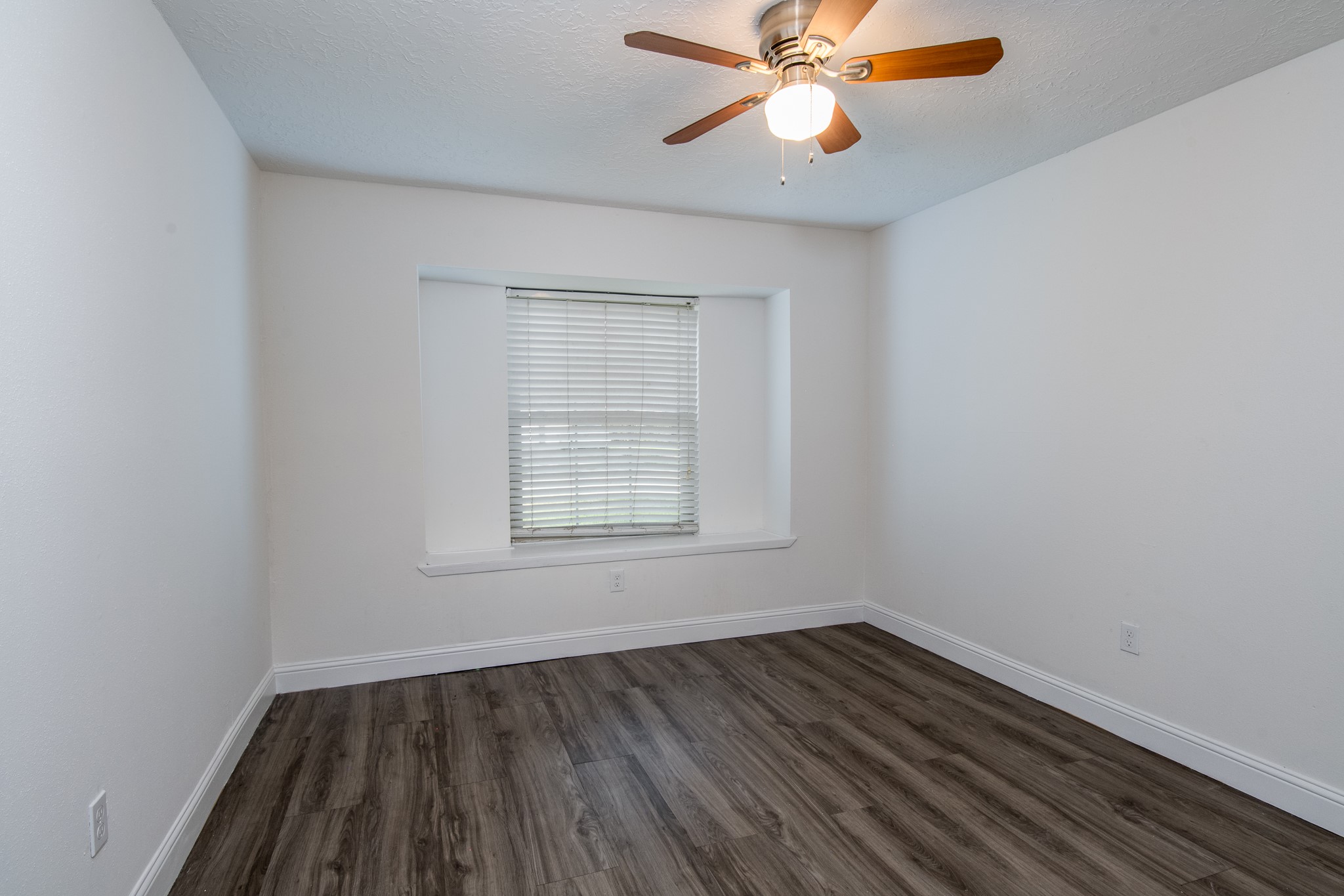 9707 Whitepost Lane Houston, TX 77086 - Photo 27 of 30 an empty room with wooden floor fan and windows