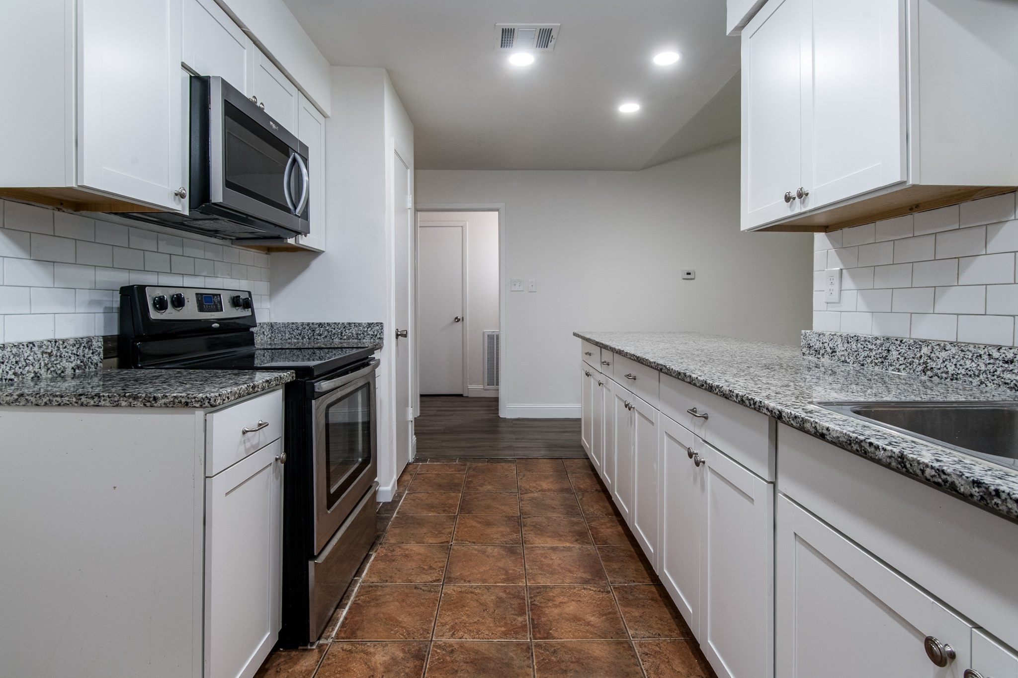 9707 Whitepost Lane Houston, TX 77086 - Photo 3 of 30 a kitchen with granite countertop kitchen island stainless steel appliances a sink stove top oven and cabinets