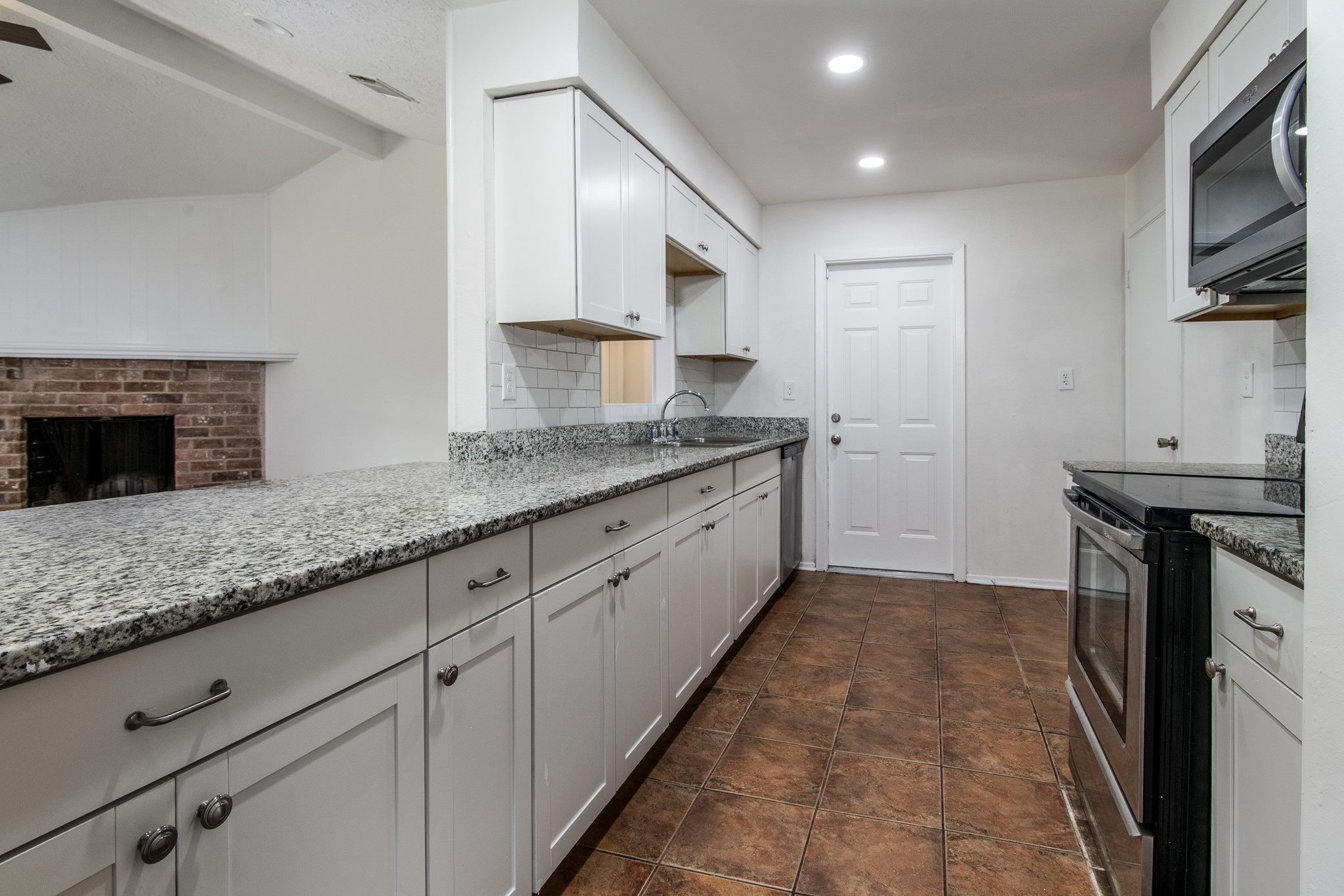 9707 Whitepost Lane Houston, TX 77086 - Photo 4 of 30 a kitchen with granite countertop a sink a counter top space cabinets and stainless steel appliances