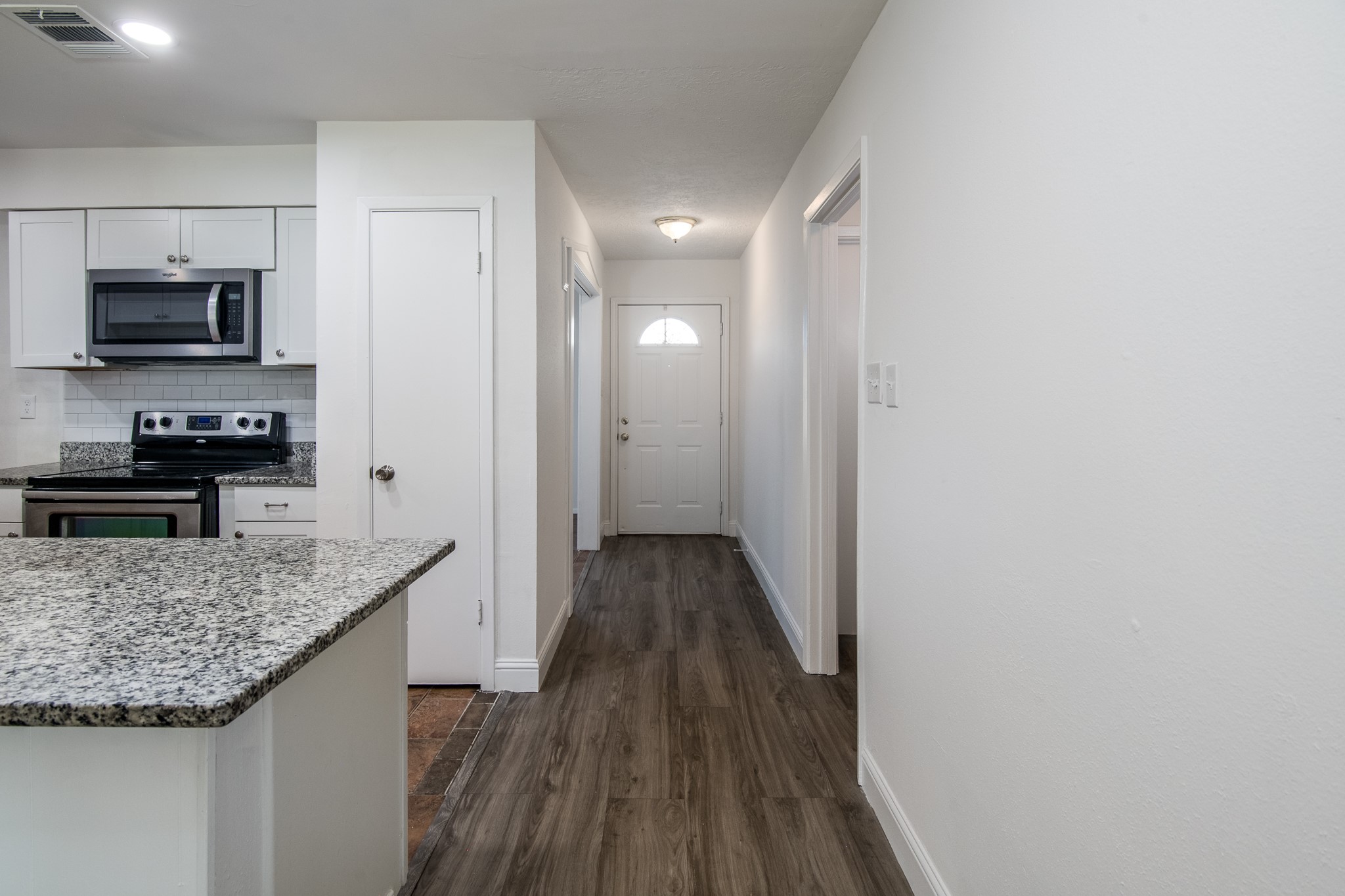9707 Whitepost Lane Houston, TX 77086 - Photo 5 of 30 a view of a kitchen cabinets a kitchen island wooden floor and stainless steel appliances