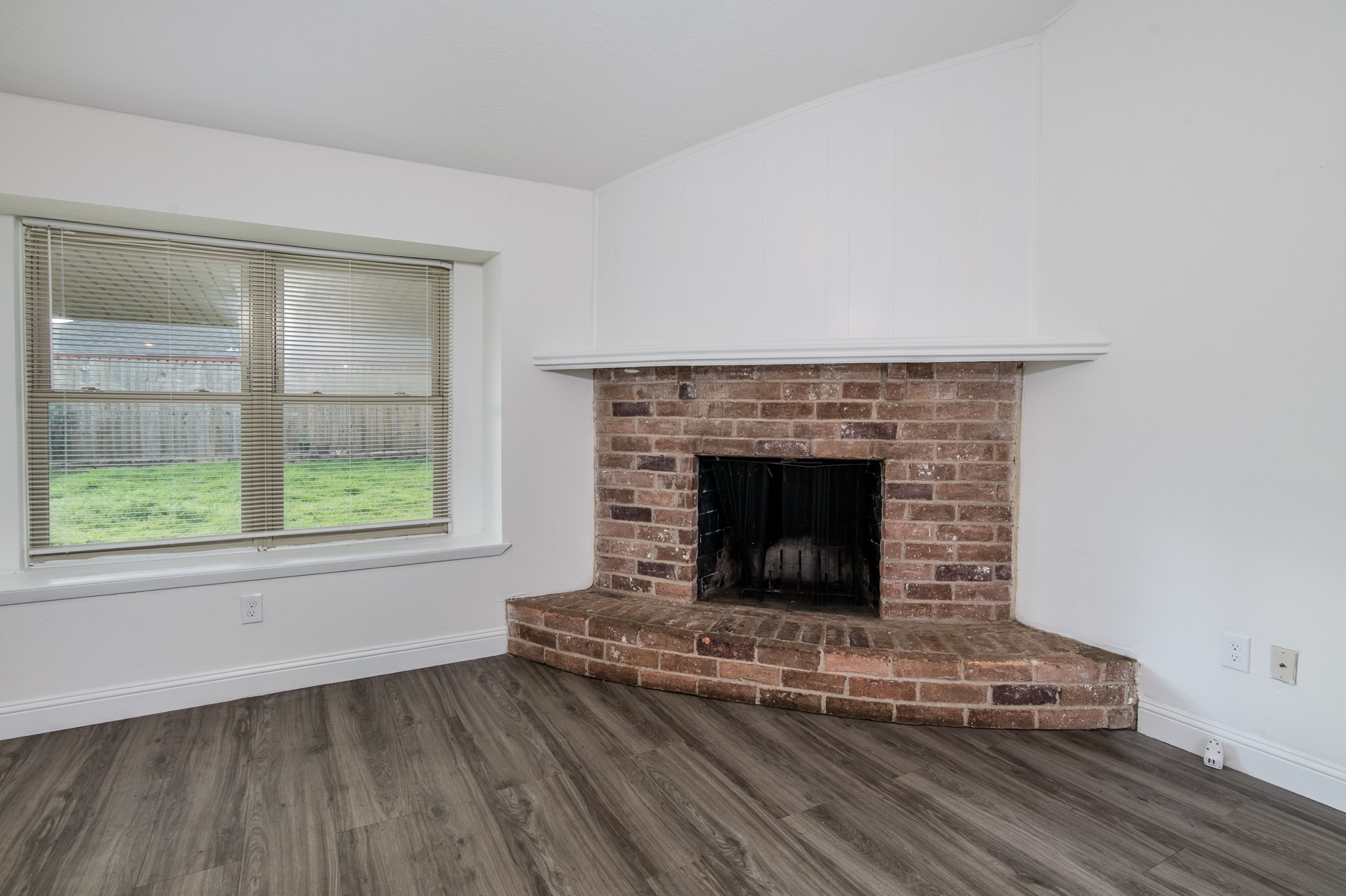 9707 Whitepost Lane Houston, TX 77086 - Photo 9 of 30 an empty room with wooden floor and fireplace