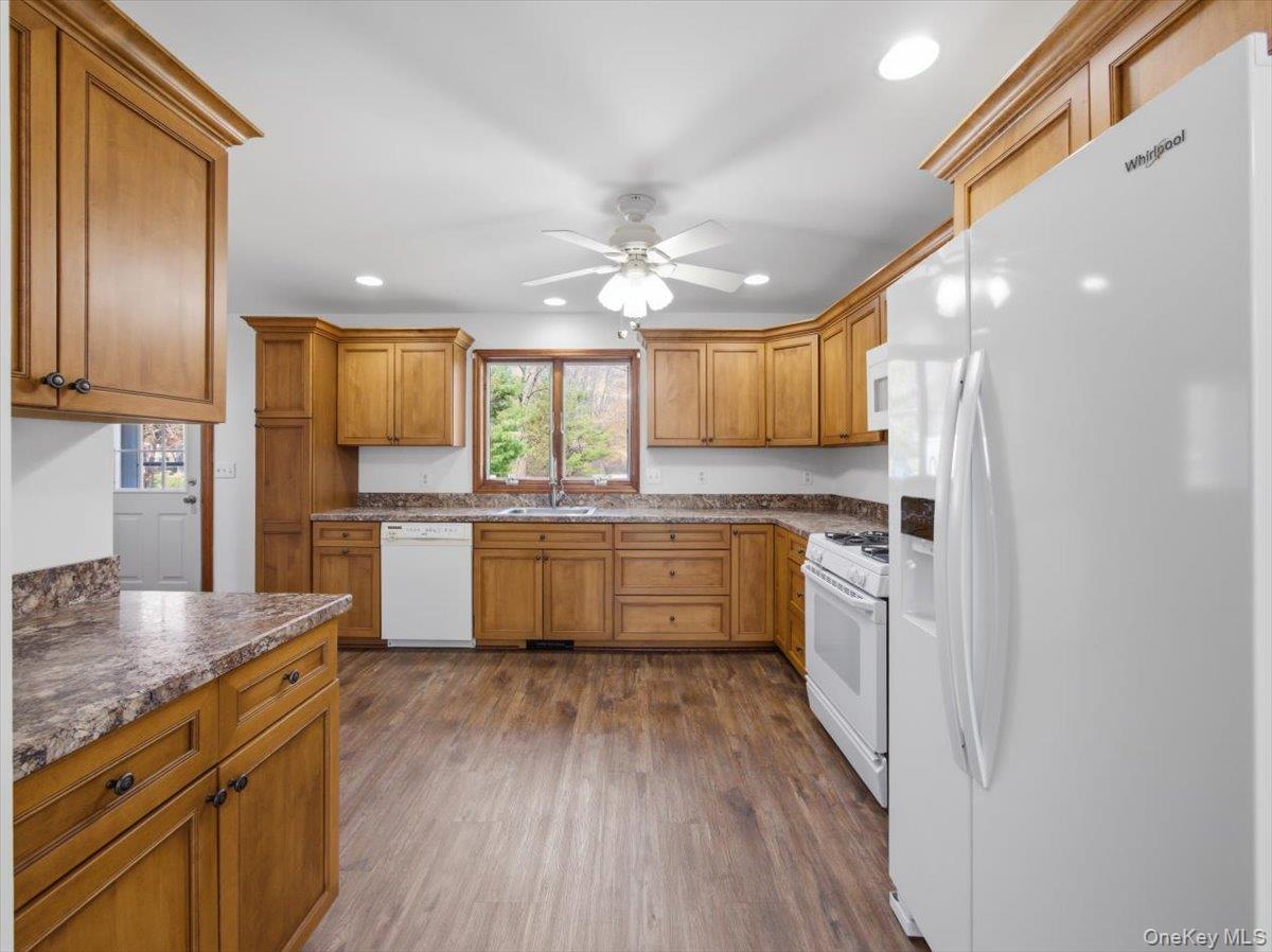 311 Gate Hill Coop Road Stony Point, NY 10980 - Photo 13 of 42 The kitchen features wooden cabinetry, white appliances, and a window above the sink