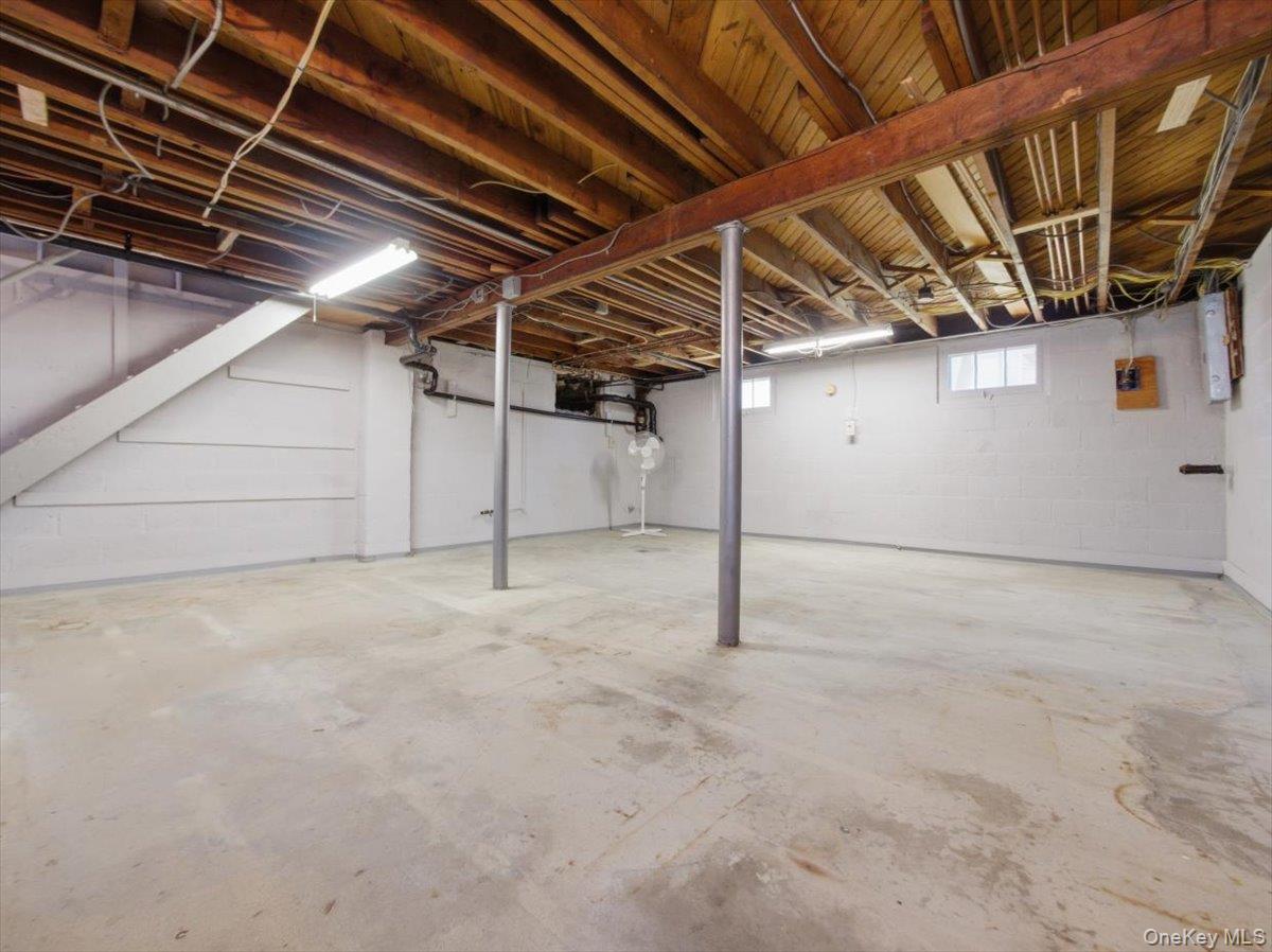 311 Gate Hill Coop Road Stony Point, NY 10980 - Photo 31 of 42 Spacious lower level with an unfinished concrete floor, exposed wooden ceiling beams, and white painted walls