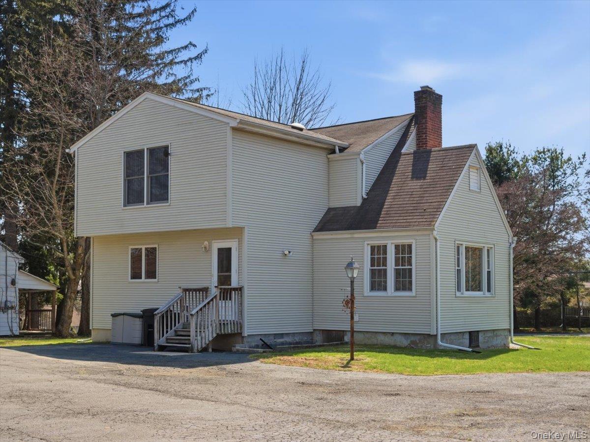 311 Gate Hill Coop Road Stony Point, NY 10980 - Photo 34 of 42 The property features light-colored siding, a sloped roof, and a prominent brick chimney