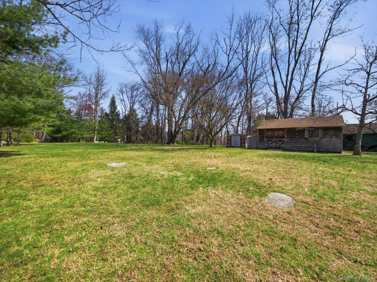 311 Gate Hill Coop Road Stony Point, NY 10980 - Photo 36 of 42 Expansive outdoor space featuring a lush lawn, mature trees, and a rustic outbuilding