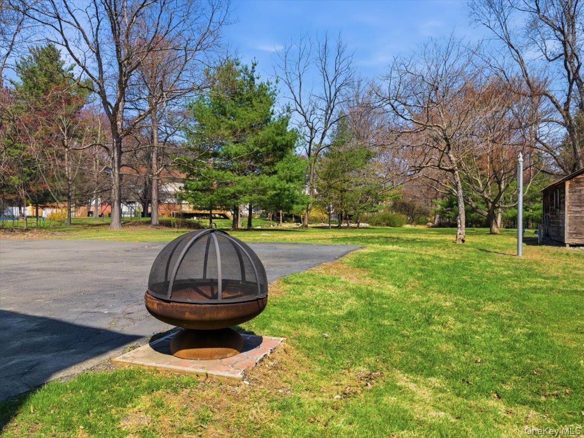 311 Gate Hill Coop Road Stony Point, NY 10980 - Photo 38 of 42 Expansive yard featuring a well-maintained lawn, mature trees, and a fire pit on a brick base