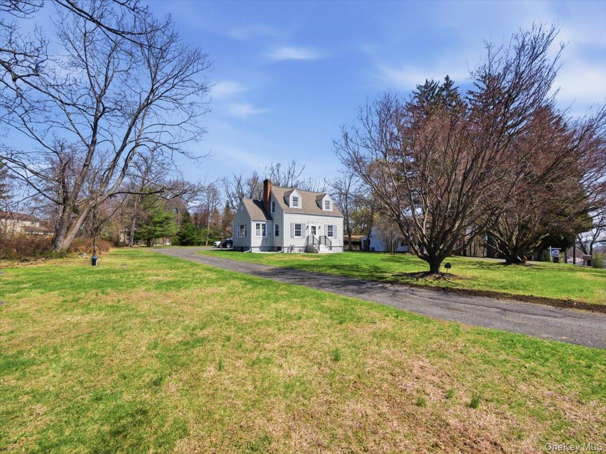 311 Gate Hill Coop Road Stony Point, NY 10980 - Photo 4 of 42 The property features a well-maintained lawn and mature trees, with a paved driveway leading to a charming residence