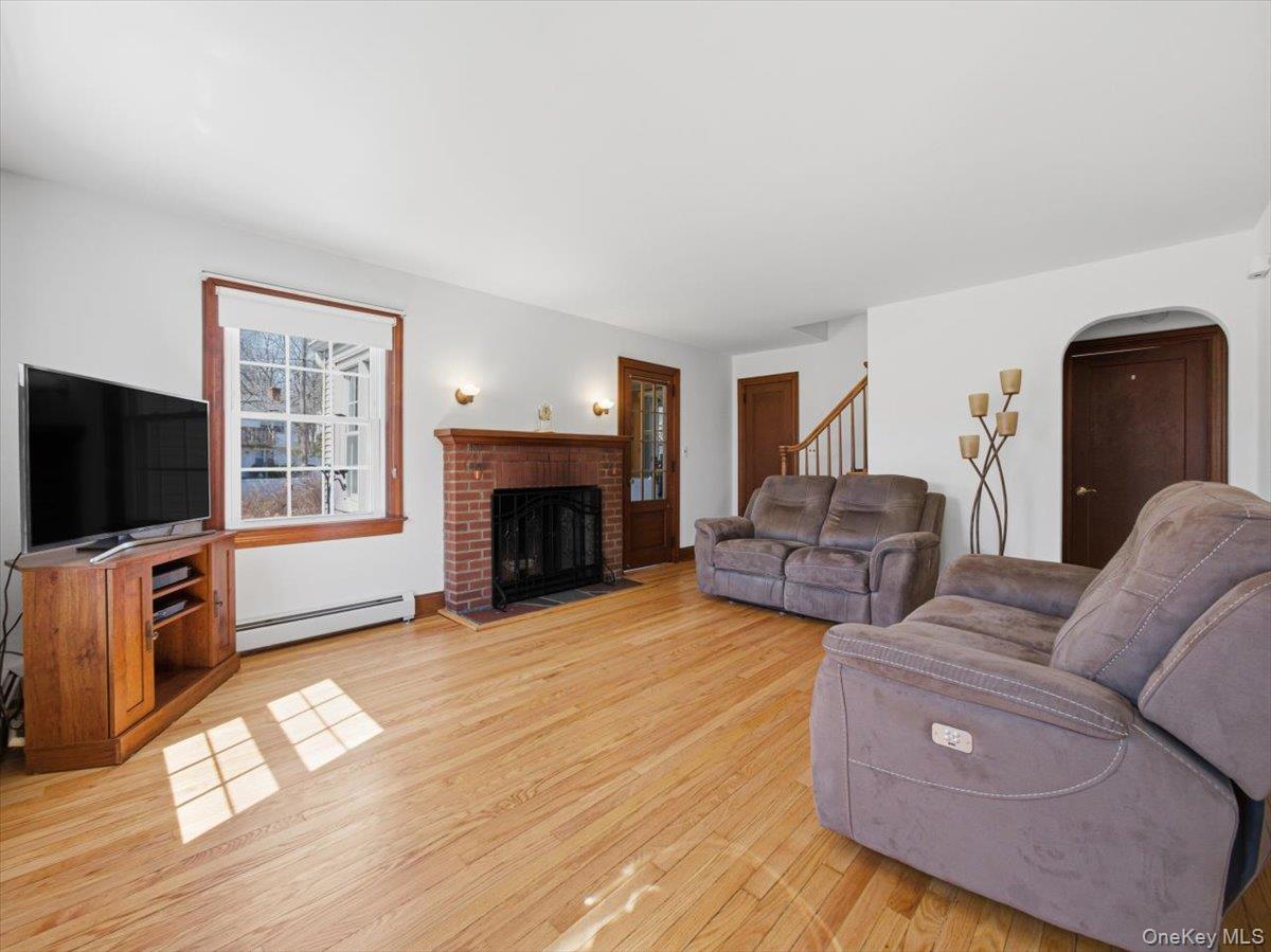 311 Gate Hill Coop Road Stony Point, NY 10980 - Photo 7 of 42 Living room featuring hardwood floors, a brick fireplace with a wood mantle, and a window with wood trim