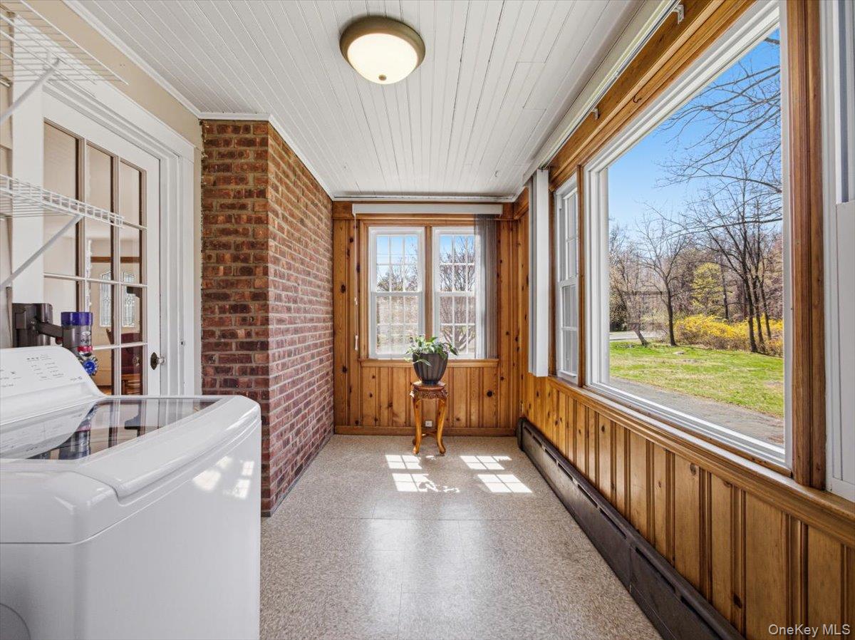 311 Gate Hill Coop Road Stony Point, NY 10980 - Photo 9 of 42 This bright room features wide windows offering views of the outdoors, a brick wall, and wood paneling