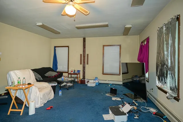 a living room with furniture and a painting on the wall