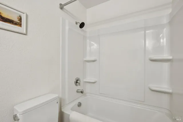 a bath room with a toilet and a bath tub