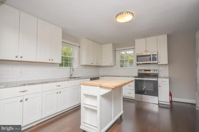 a bathroom with a granite countertop sink a toilet and a mirror