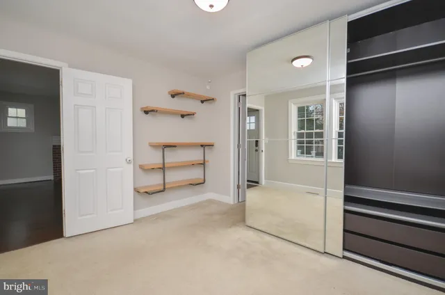 a view of an empty walk in closet and bedroom
