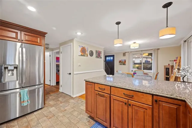 a kitchen with stainless steel appliances granite countertop a refrigerator a oven a sink with island and chairs