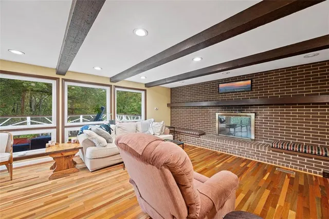 a living room with furniture floor to ceiling window and wooden floor