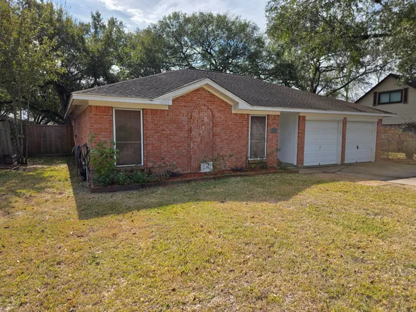 a view of a house with a yard and large tree