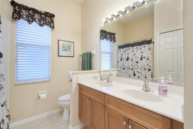 a bathroom with a sink a toilet a mirror and shower