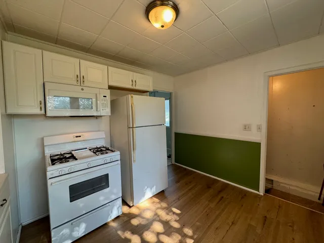 a kitchen with granite countertop white cabinets and stainless steel appliances