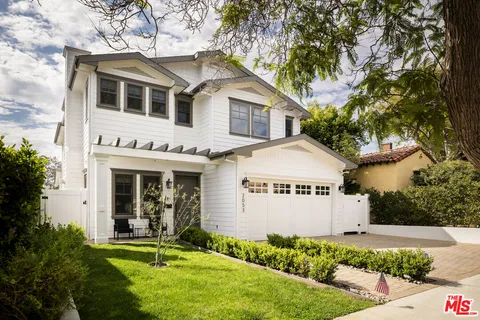 a front view of a house with a yard and trees