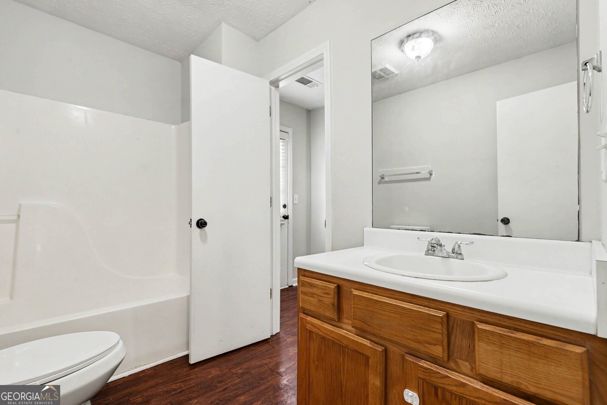 209 East Wilson Street Villa Rica, GA 30180 - Photo 21 of 24 HALL FULL BATHROOM WITH LAMINATE FLOORING, NEW TOILET AND NEW INTERIOR PAINT.