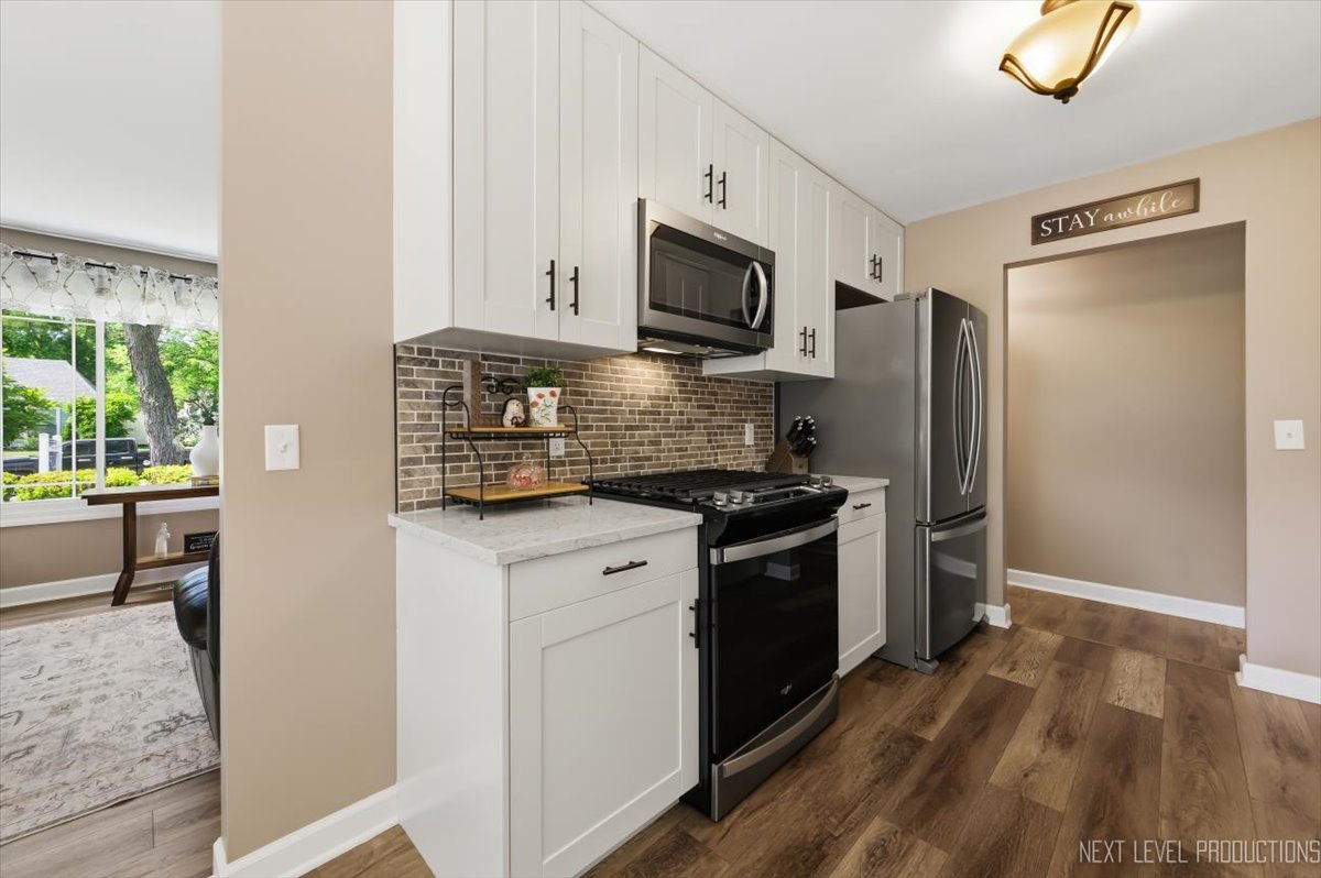 10 Shermead Road Montgomery, IL 60538 - Photo 11 of 30 a kitchen with stainless steel appliances granite countertop a refrigerator stove and sink