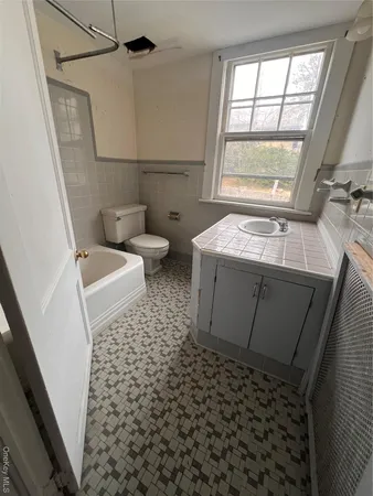 a bathroom with a sink a toilet and a window