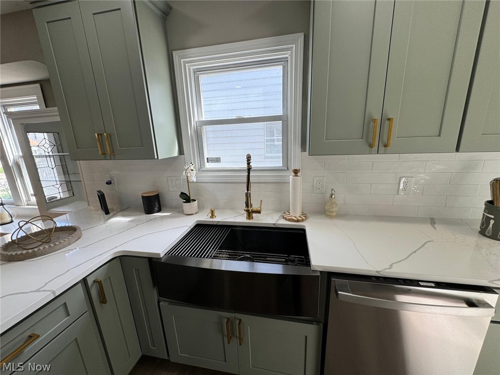 3356 Berea Road Cleveland, OH 44111 - Photo 13 of 35 Kitchen with tasteful backsplash, stainless steel dishwasher, and light stone countertops